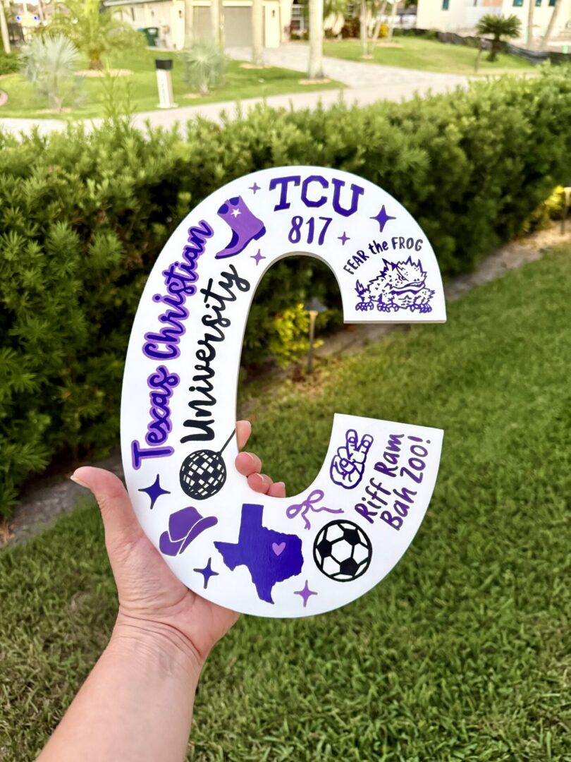 Hand holding TCU-themed decorative letter C