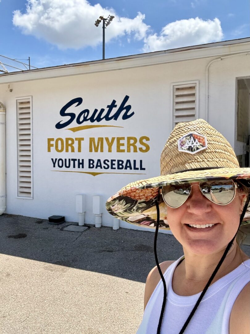 Person smiling at South Fort Myers baseball sign
