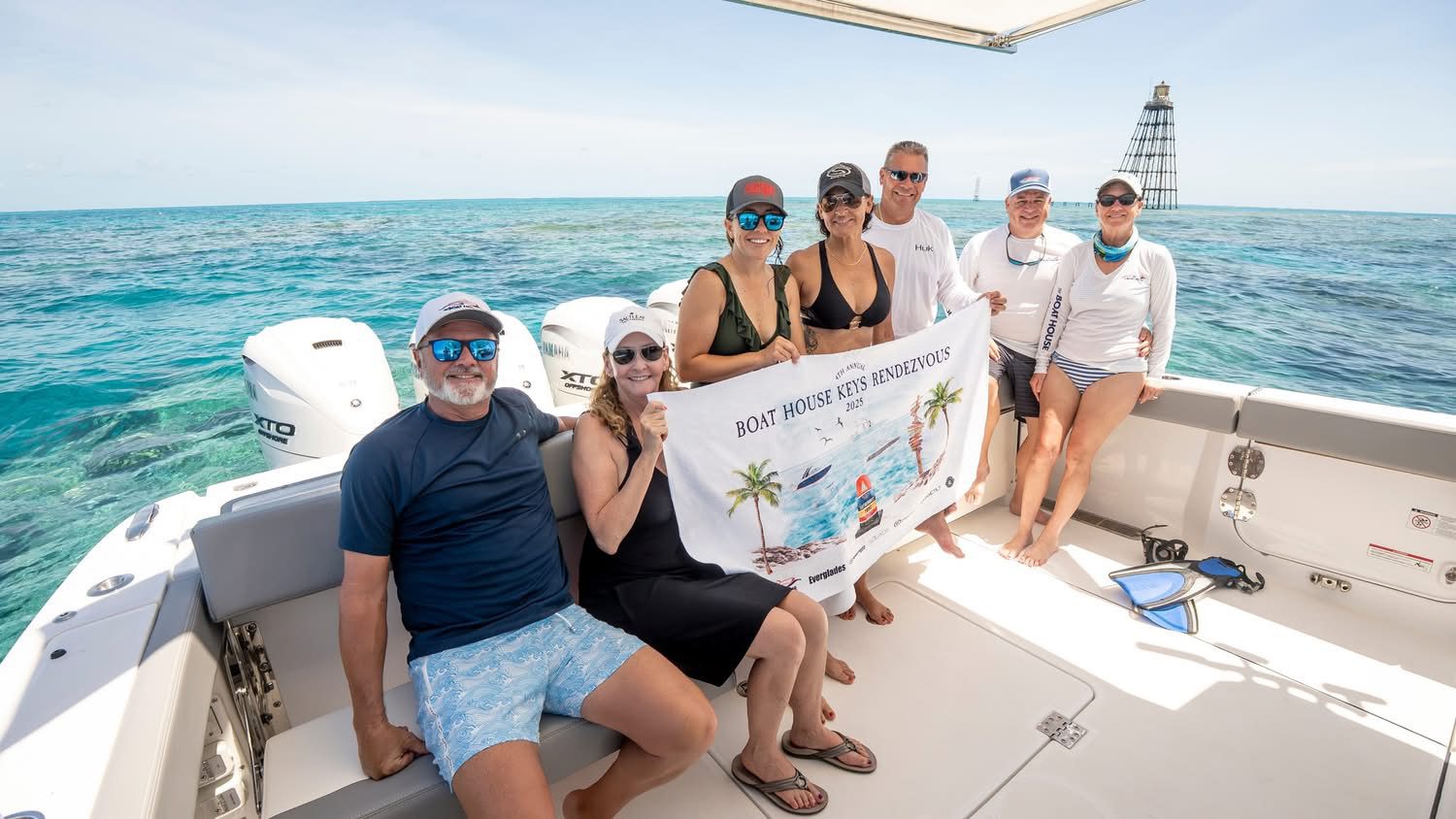 Group on boat holding banner at sea